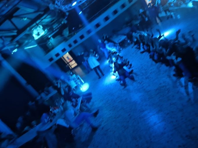 Feiernde Gäste im blauen Licht